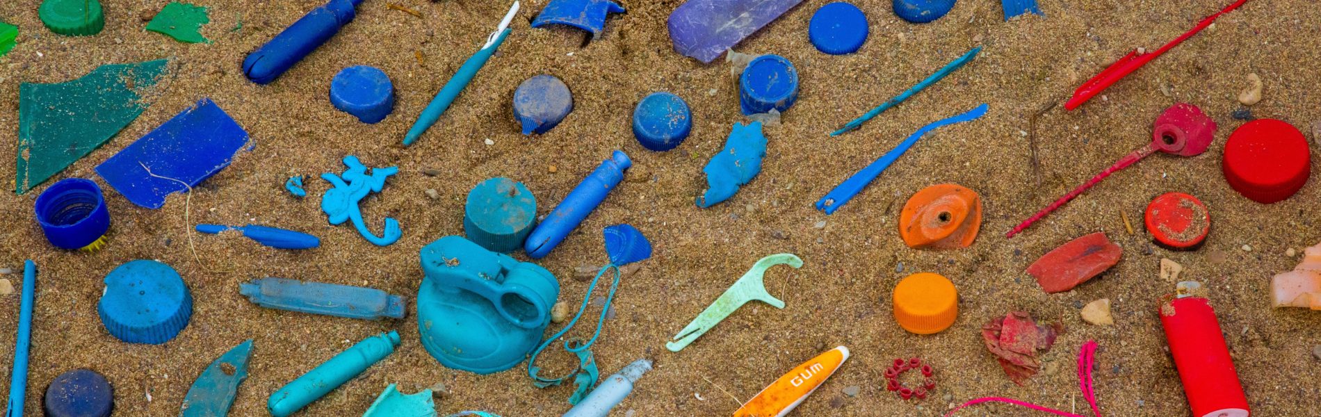 Colourful plastic objects arranged on sand