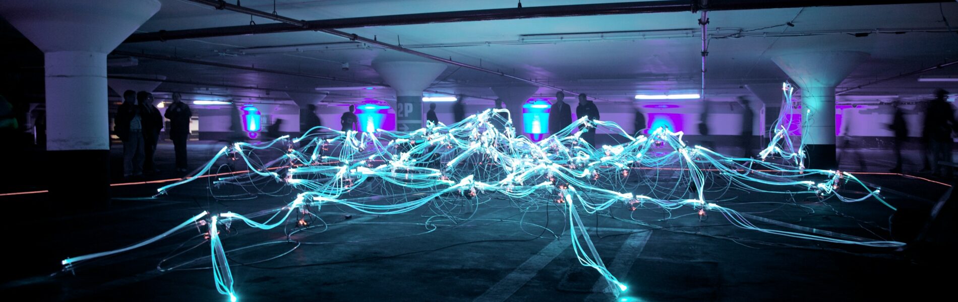 Room with blue fibre optics cables arranged like a web, lit up