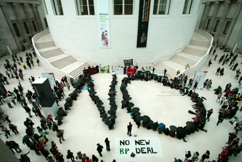 Artists and faith groups protest BP sponsorship of the Arts in the British Museum. People holding black umbrellas arranged in a formation to spell the word 'No'