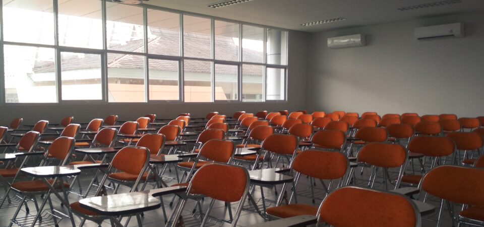 Room full of orange conference chairs, arranged in neat rows