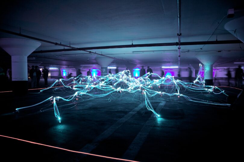 Room with blue fibre optics cables arranged like a web, lit up
