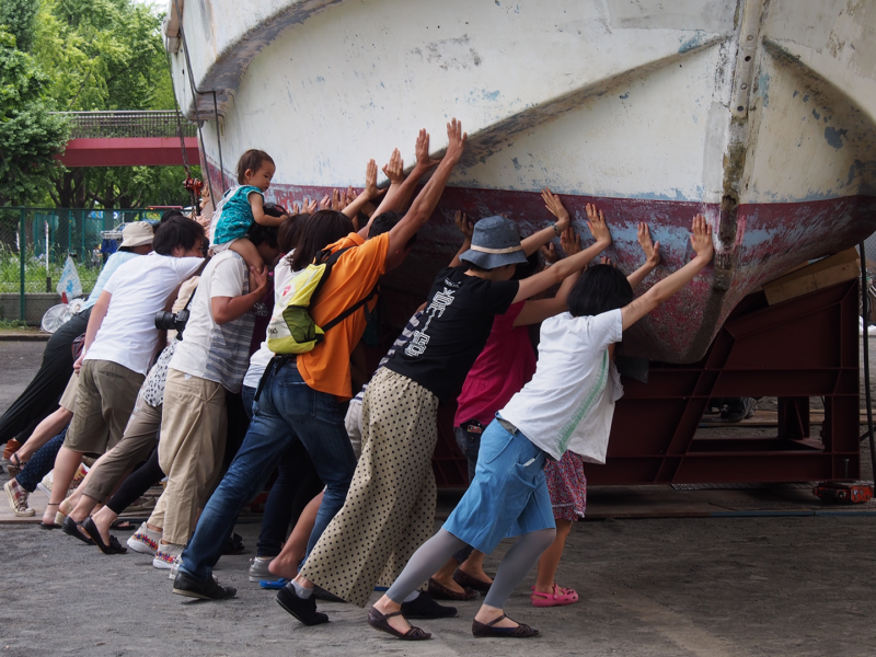 people trying to push a boat