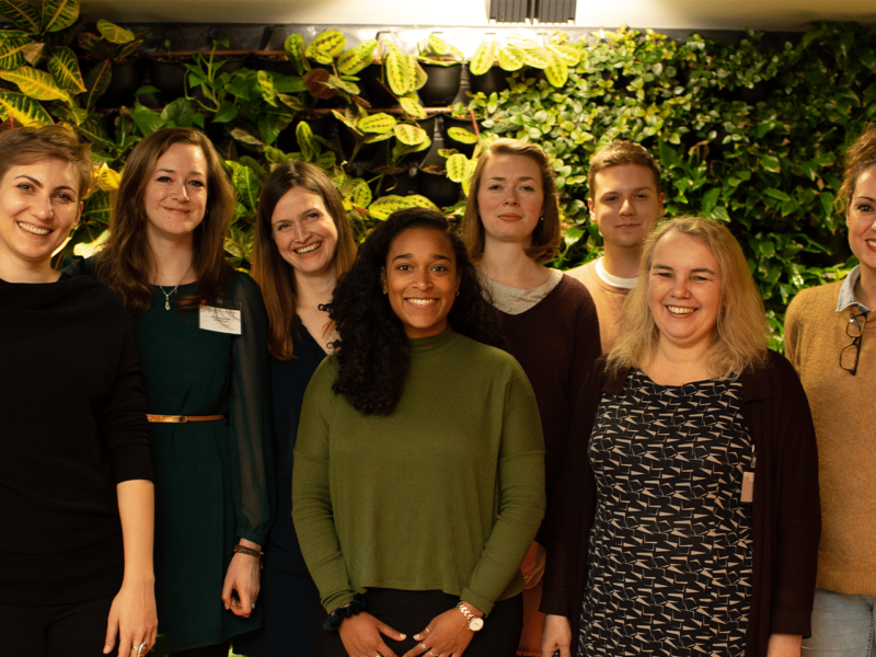 JB team gather after an event against a leafy background