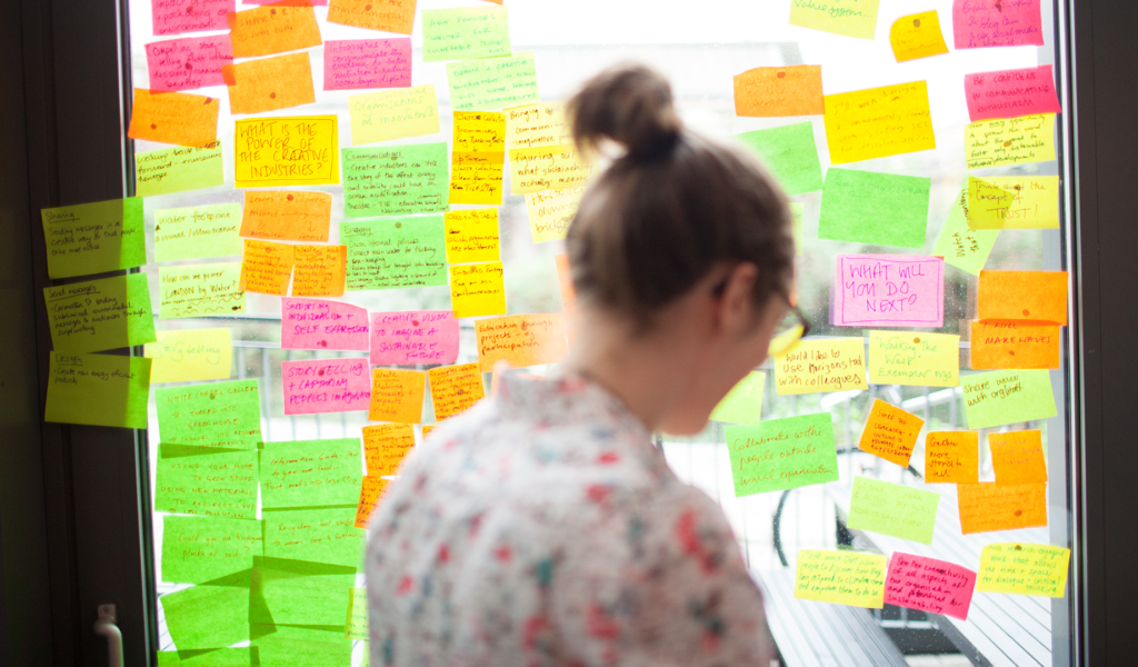 Workshop participant from behind in front of a wall of postits