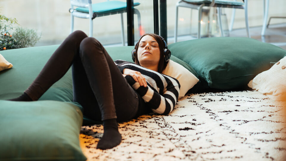 Person listening to headphones lying down