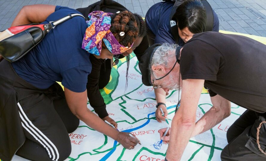 A group of people drawing on a large map of south london