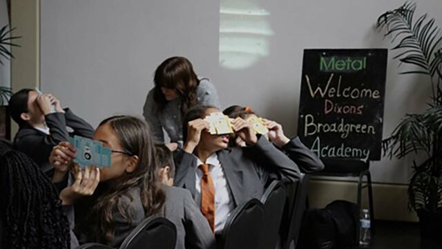 School children looking through makeshift devices in a classroom