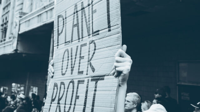 Protest placard that reads 'planet over profit'