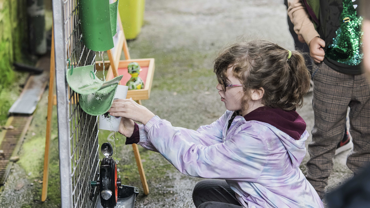 Child pouring water into cup