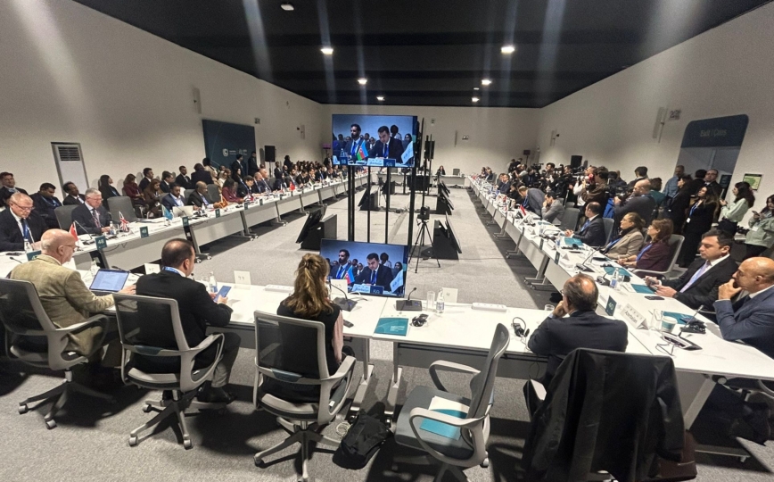 Brightly lit and busy conference room packed with cop delegates sitting in a swuare formation facing each other