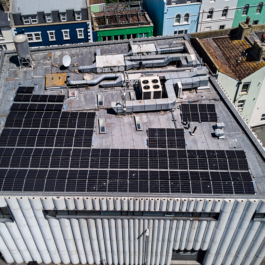 Birds eye view of the Creative Folkestone building in Kent, grey with corrugated design and solar panels on its roof.